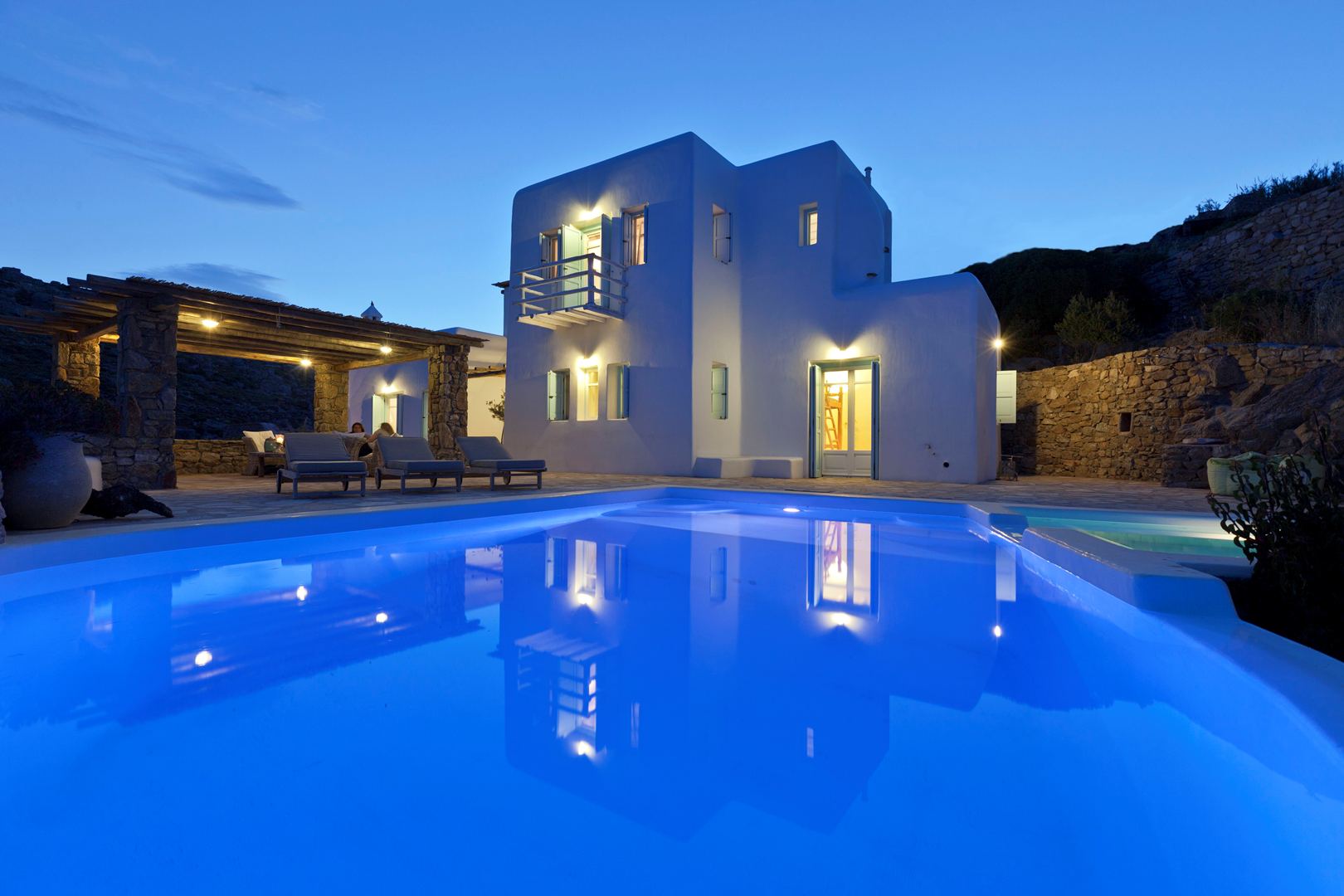 Luxury Mykonos villa with private illuminated pool at dusk